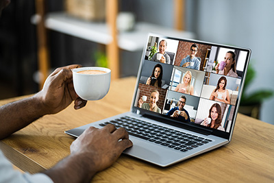 Person with coffee on laptop with video call of others with coffee